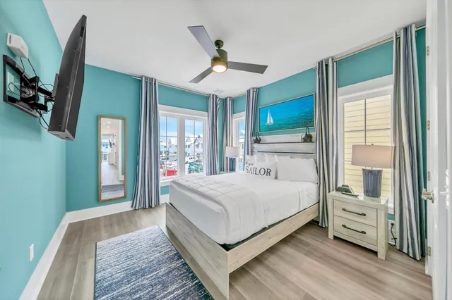 a bedroom with a large bed a flat tv screen and dresser