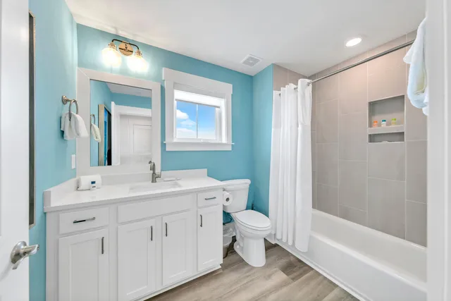 a bathroom with a double vanity sink a toilet and a bathtub