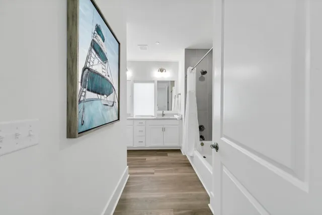 a view of a hallway with wooden floor and staircase