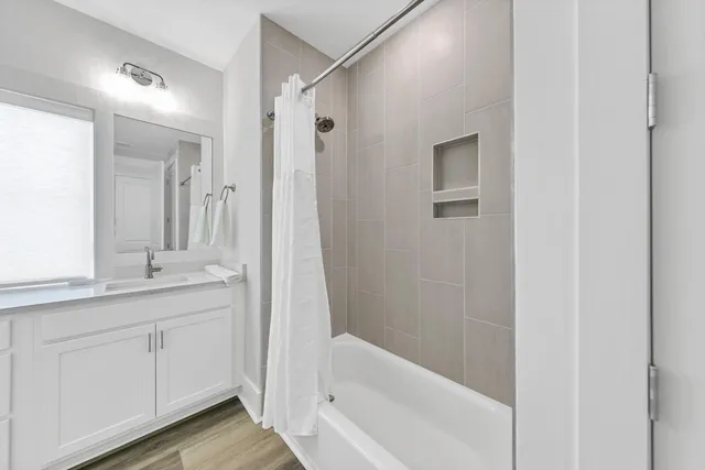 a bathroom with a tub sink and mirror