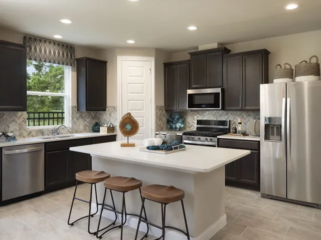 a kitchen with sink a microwave a refrigerator and cabinets