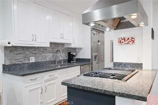 a kitchen with stainless steel appliances granite countertop a sink stove and cabinets