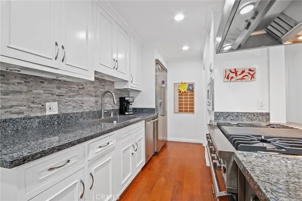 a kitchen with stainless steel appliances granite countertop a stove a sink and a refrigerator