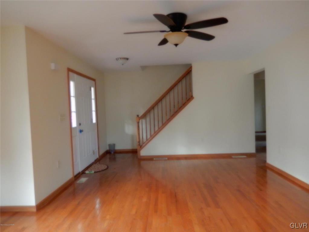5886 Decker Road Bushkill, PA 18324 - Photo 5 of 15 a view of a hallway with wooden floor and a chandelier fan