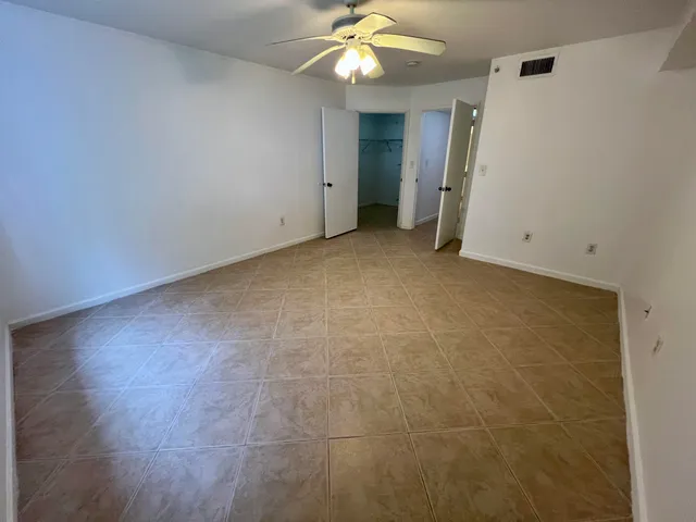 wooden floor in an empty room with a ceiling fan