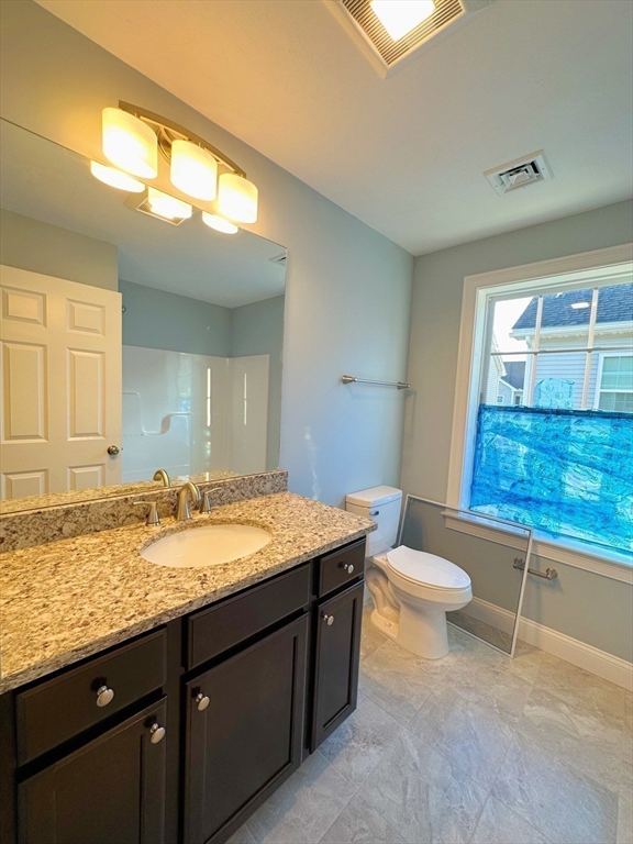 1400 Gorham Street, Unit 36 Lowell, MA 01852 - Photo 12 of 17 a bathroom with a granite countertop sink toilet and mirror