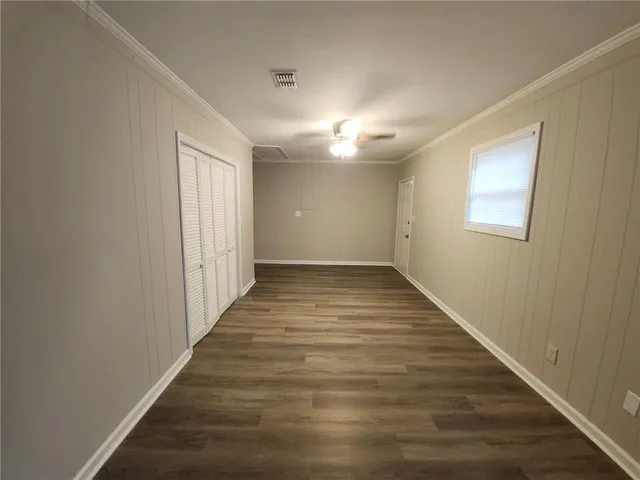 a view of an empty room with wooden floor