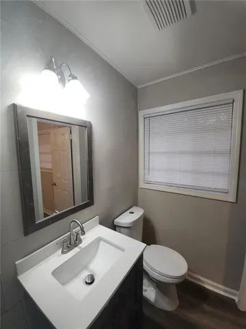 a bathroom with a toilet a sink and mirror