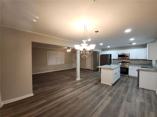 a view of a dining room with furniture a chandelier and wooden floor