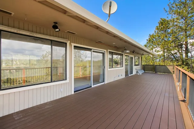 a view of a balcony with wooden floor and fence