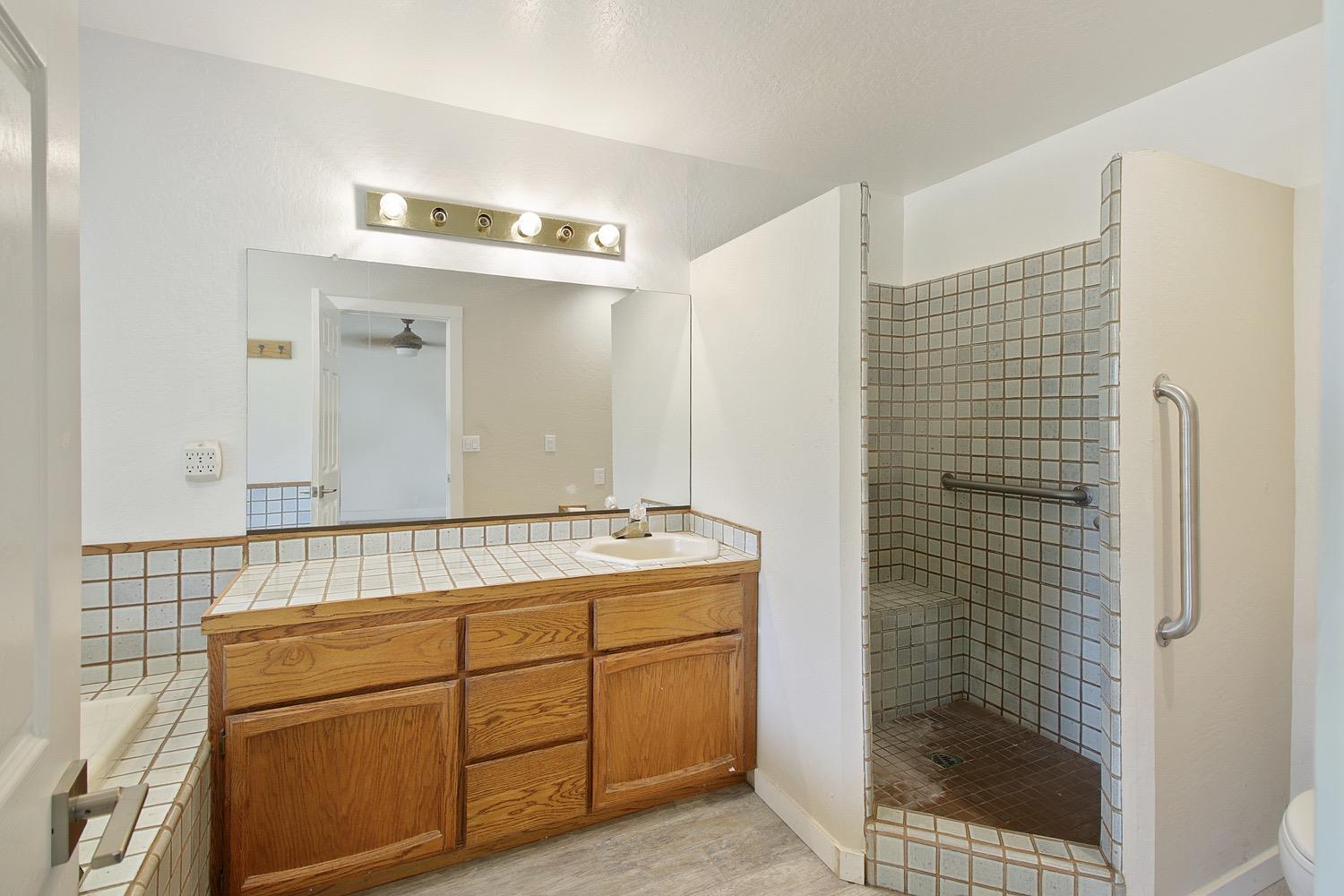 1276 Coon Court Cool, CA 95614 - Photo 37 of 79 a bathroom with a shower sink and mirror