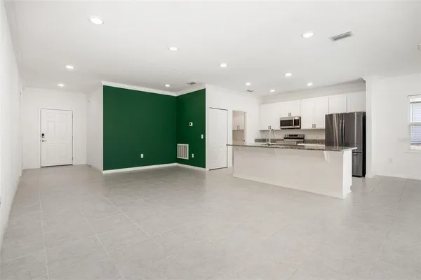 a kitchen with stainless steel appliances granite countertop a refrigerator a stove and a sink