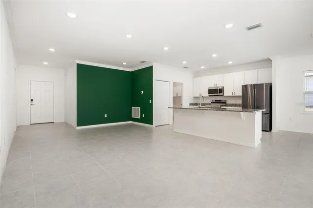 a kitchen with stainless steel appliances granite countertop a refrigerator a stove and a sink