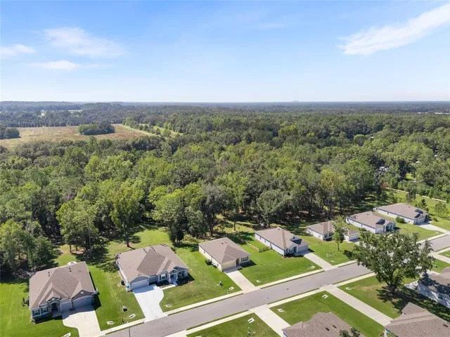 a aerial view of a house with a yard table and chairs