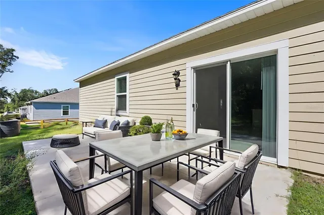 a view of a patio with a dining table and chairs with wooden floor and fence
