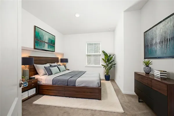 a bedroom with a bed and a potted plant