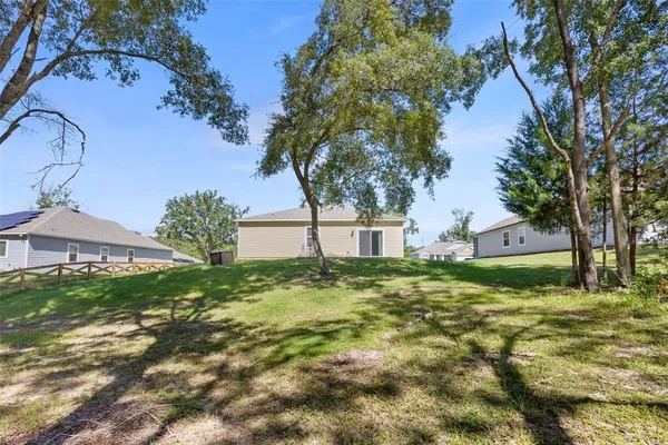 a large tree in front of a house with a yard