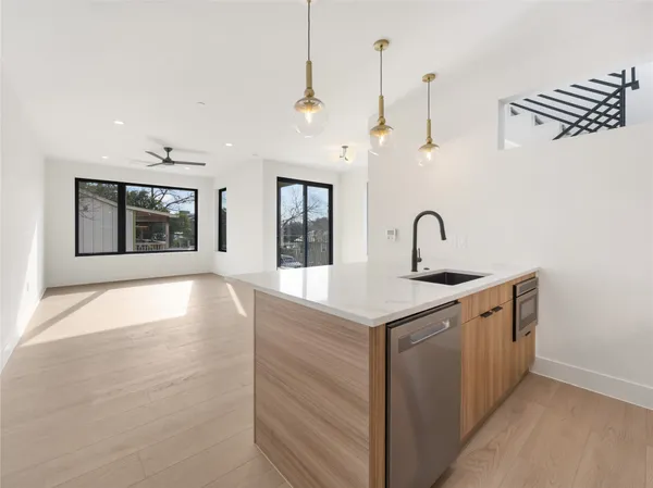a kitchen with stainless steel appliances granite countertop a sink a stove and a wooden floor