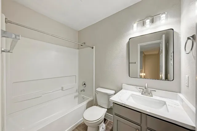 a bathroom with a sink toilet vanity and shower