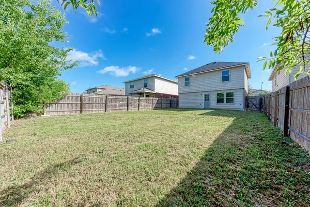 a view of a house with a big yard and large tree