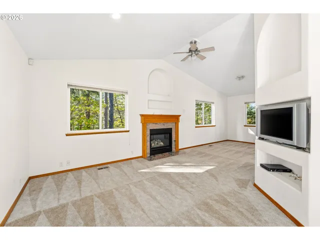 a view of empty room with fireplace and fan