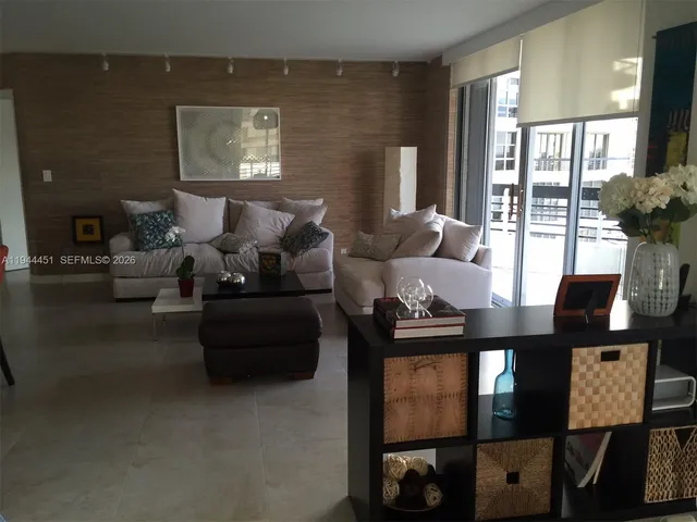 a living room with furniture and a floor to ceiling window