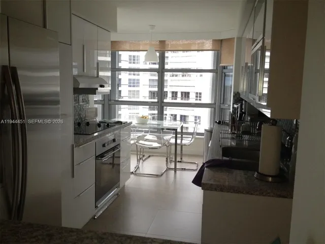 a kitchen with stainless steel appliances granite countertop a refrigerator and a stove
