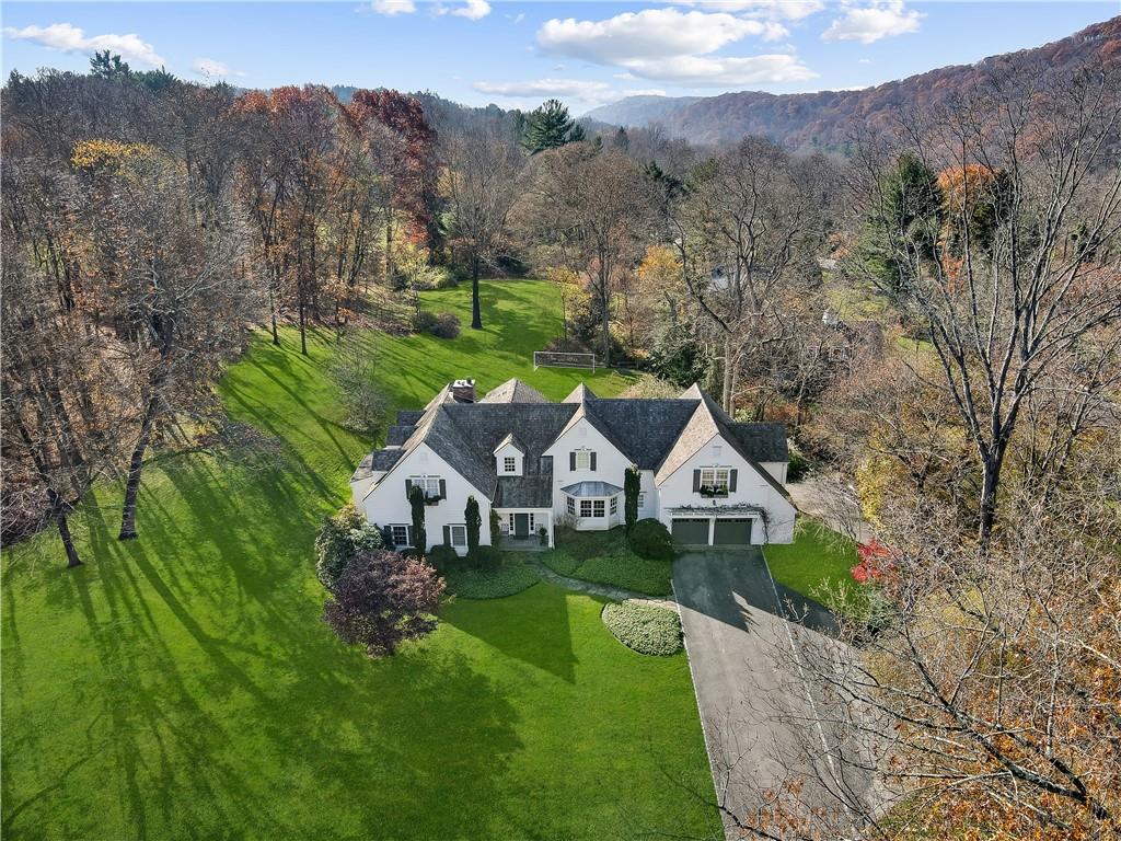 a view of a house with a big yard and large trees