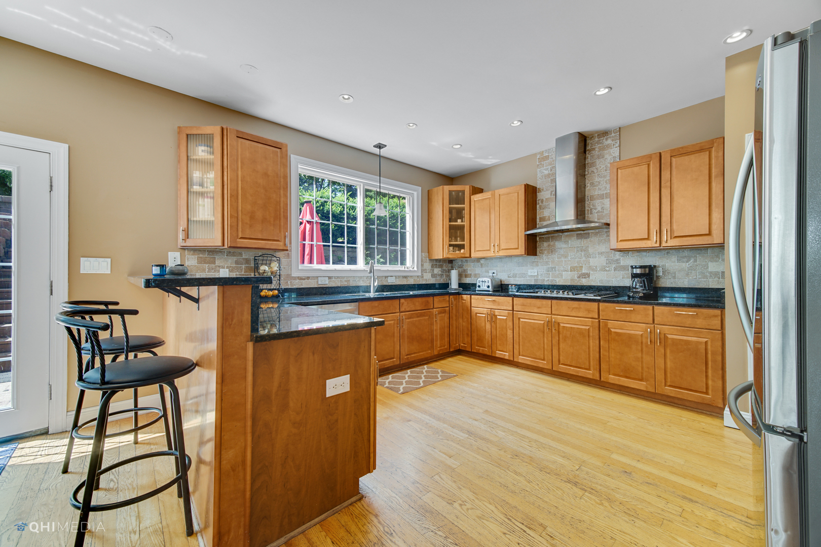 5213 Hayes Road Algonquin, IL 60102 - Photo 4 of 36 a kitchen with stainless steel appliances granite countertop wooden cabinets a stove a sink and a large window