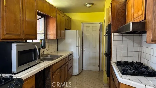 a kitchen with a sink a refrigerator and cabinets