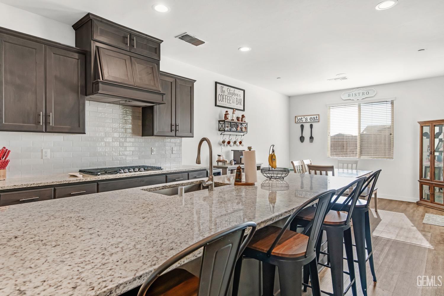 Undisclosed Address Bakersfield, CA 93313 - Photo 8 of 45 a kitchen with stainless steel appliances granite countertop a stove top oven a sink a dining table and chairs