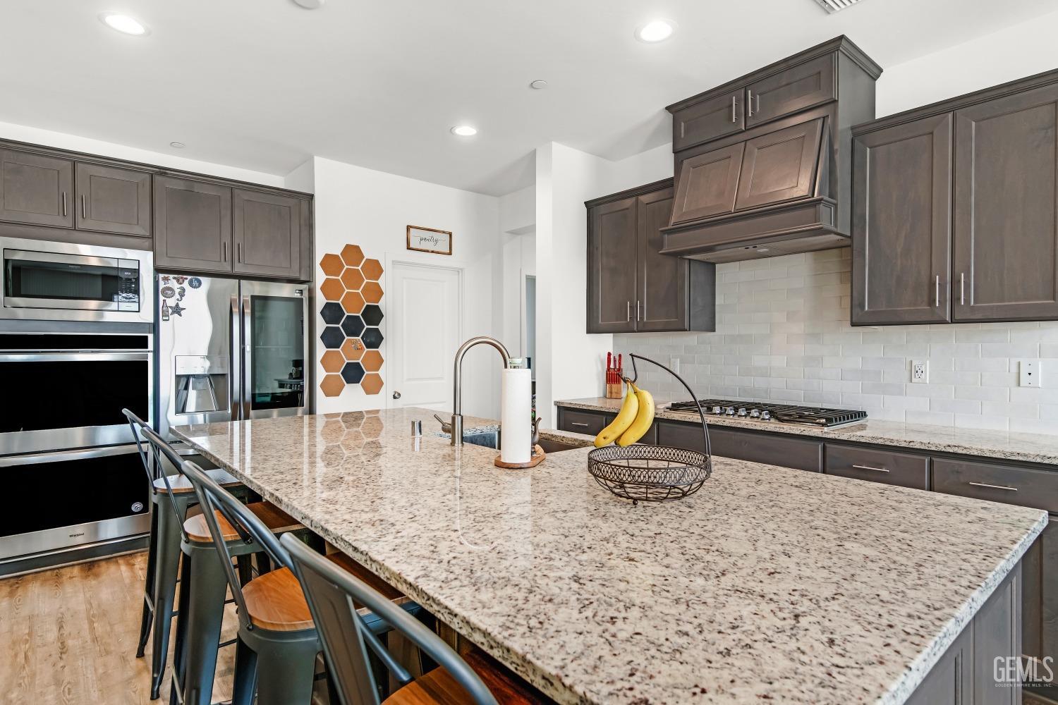 Undisclosed Address Bakersfield, CA 93313 - Photo 9 of 45 a kitchen with kitchen island a counter top and stove
