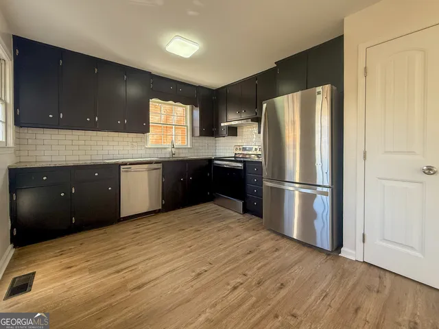 a kitchen with stainless steel appliances granite countertop a refrigerator and a sink