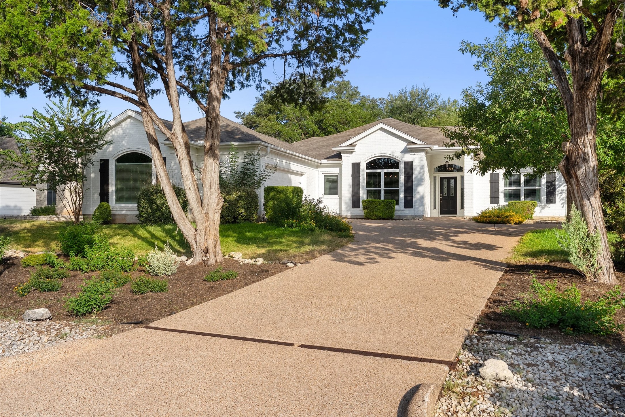 120 Copperleaf Road Lakeway, TX 78734 - Photo 2 of 30 A well-maintained facade with striking arched windows and dark shutters creates inviting curb appeal.