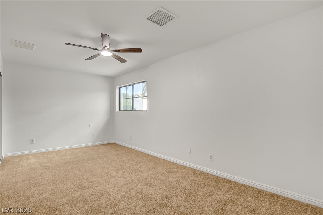 1810 Pinto Road Henderson, NV 89002 - Photo 32 of 53 A well-lit bedroom features plush carpeting and a ceiling fan for comfort.