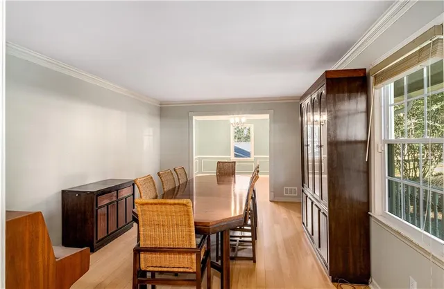 a view of a dining room with furniture a chandelier and wooden floor