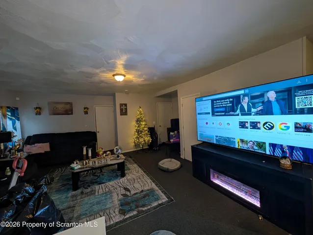 a living room with furniture a rug and a projector