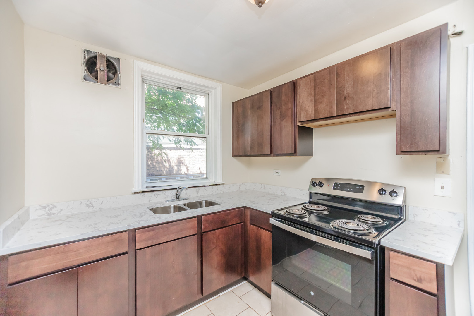 1143 East 50th Street, Unit 3S Chicago, IL 60615 - Photo 5 of 11 a kitchen with stainless steel appliances granite countertop a sink stove and cabinets