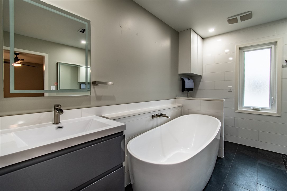 930 Waterview Street Portland, TX 78374 - Photo 16 of 38 a bathroom with a white tub sink and mirror