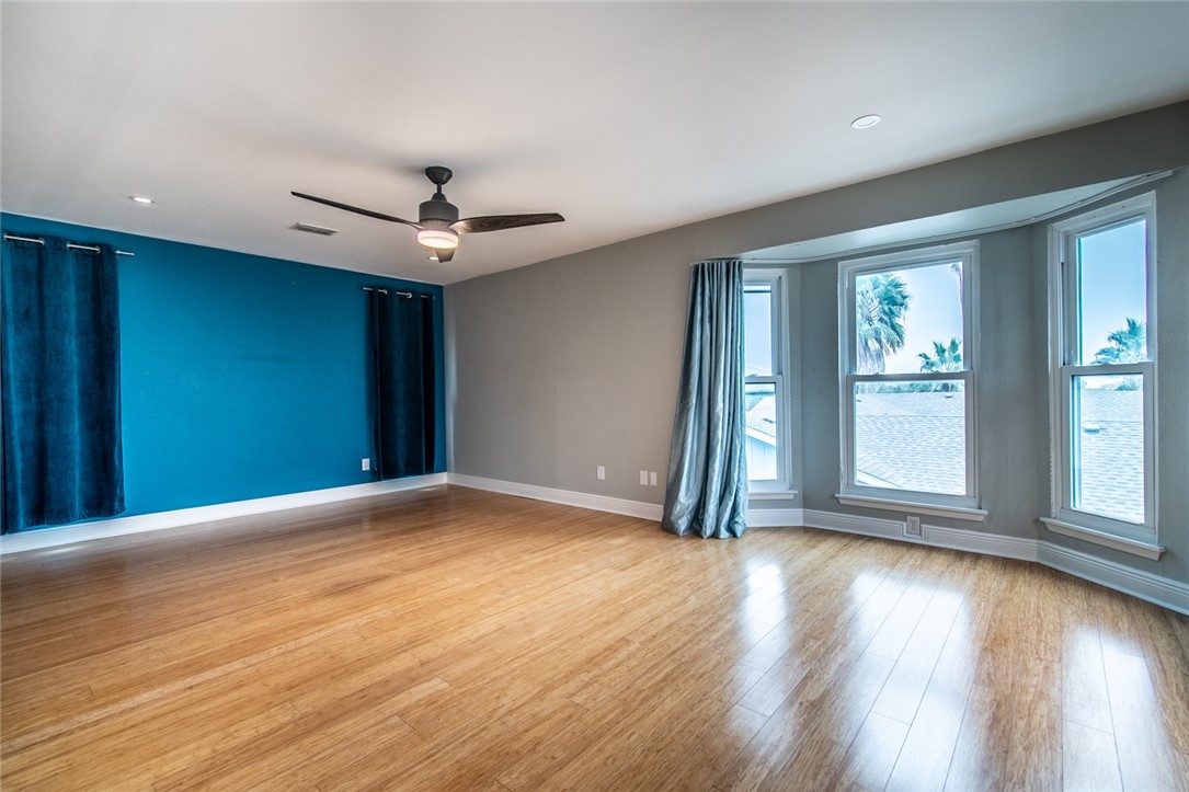 930 Waterview Street Portland, TX 78374 - Photo 28 of 38 an empty room with wooden floor chandelier fan and windows