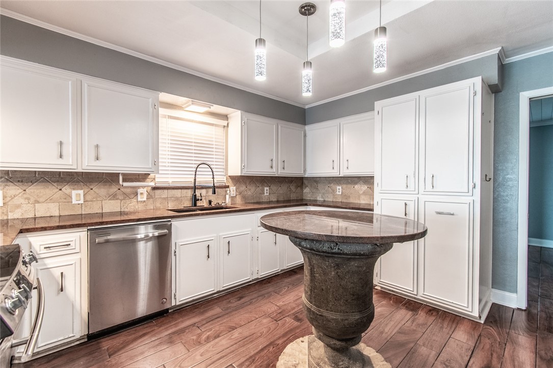 930 Waterview Street Portland, TX 78374 - Photo 34 of 38 a kitchen with stainless steel appliances granite countertop a sink a stove a refrigerator and island with wooden floor