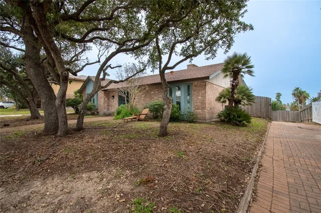 a view of a house with backyard and a tree