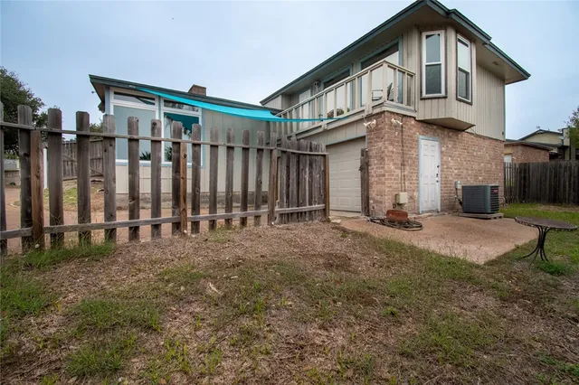 a view of a big house with wooden fence