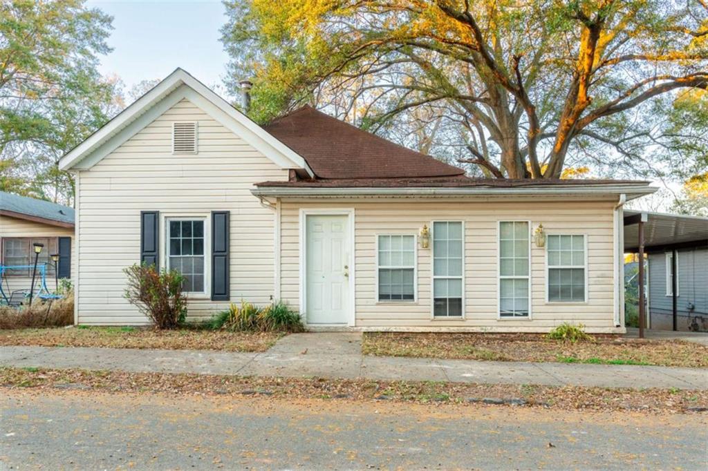 a front view of a house with a garden and plants