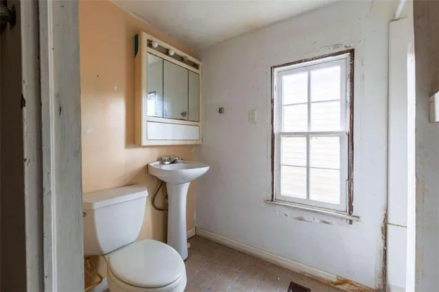 a bathroom with a toilet sink and window
