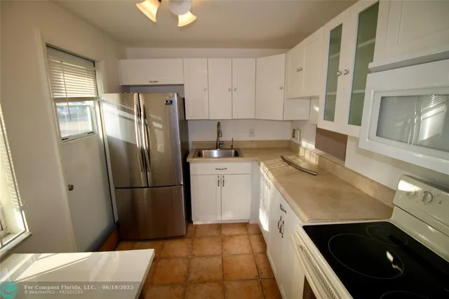 a kitchen with a refrigerator sink and cabinets