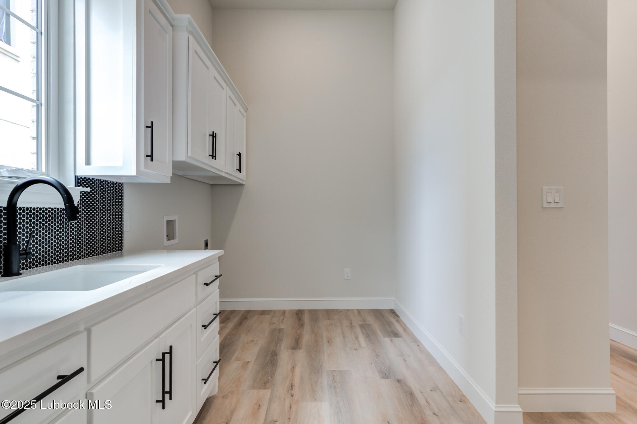 3902 148th Street Lubbock, TX 79423 - Photo 24 of 83 a view of a kitchen with sink cabinets and wooden floor