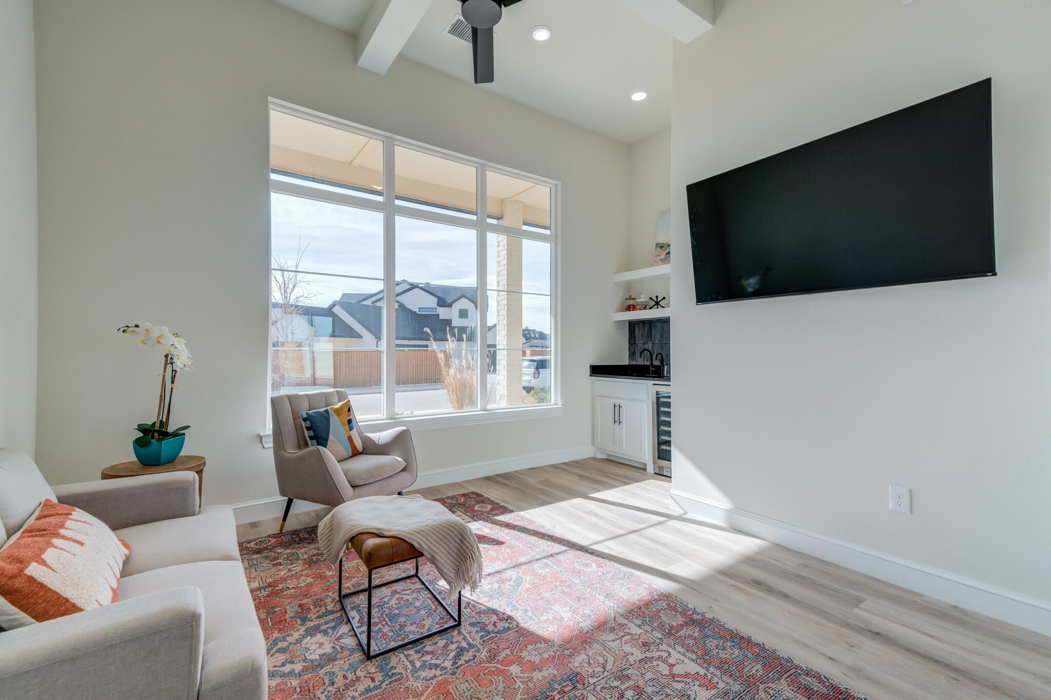 3902 148th Street Lubbock, TX 79423 - Photo 29 of 83 a living room with furniture a flat screen tv and a floor to ceiling window