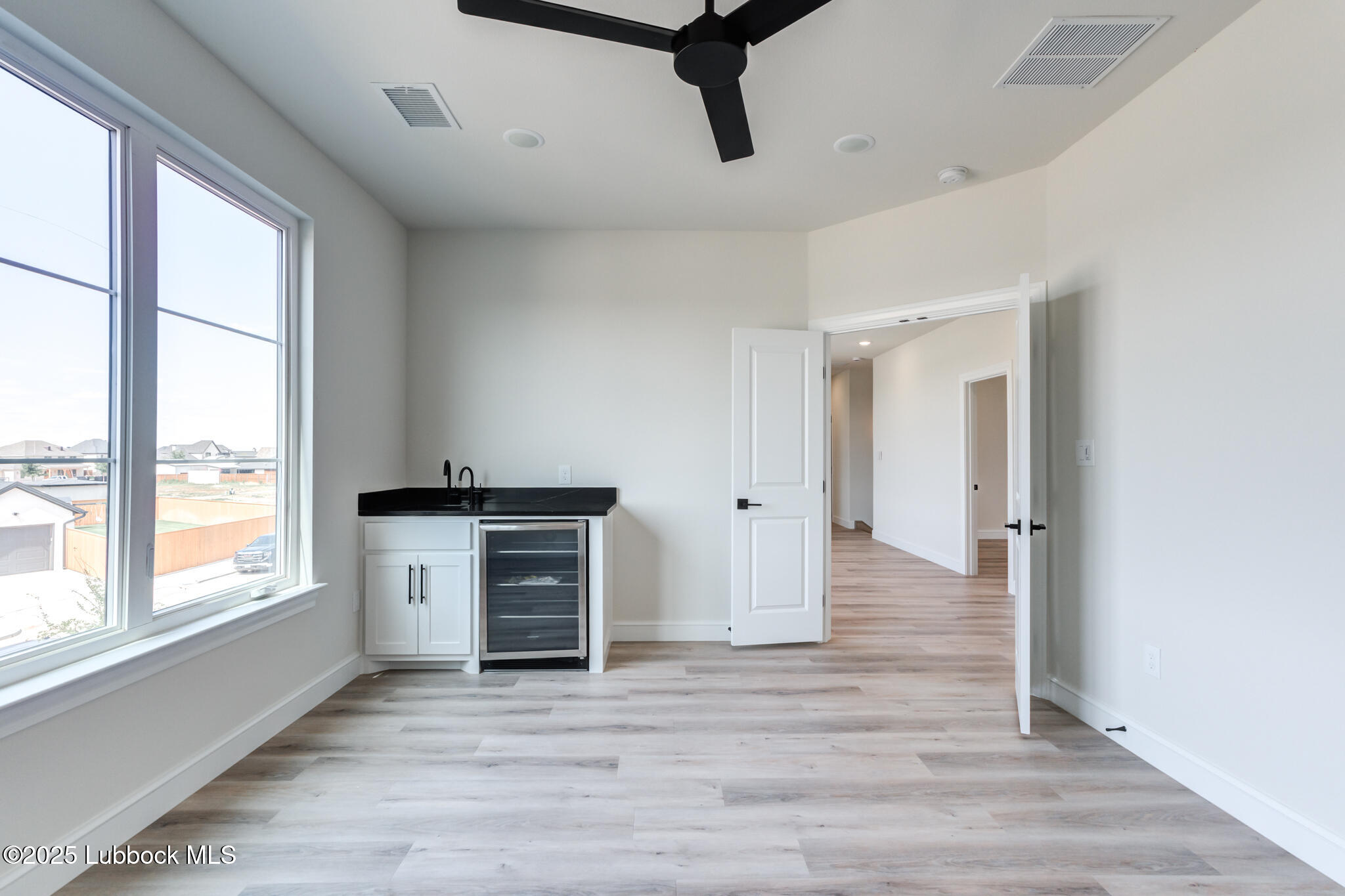 3902 148th Street Lubbock, TX 79423 - Photo 45 of 83 a view of an empty room with a window and wooden floor