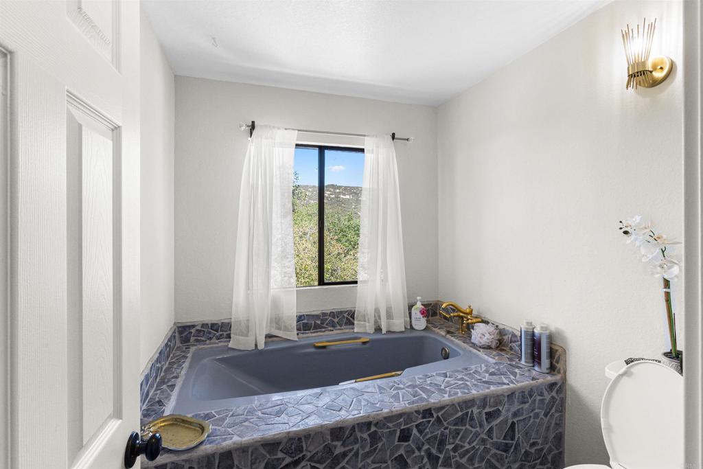 3340 Skytrail Ranch Road Jamul, CA 91935 - Photo 19 of 38 a bathroom with a granite countertop sink and a mirror